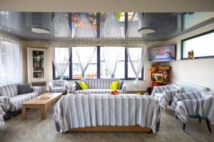 a living room with couches and tables and windows at Casa Angy in Techirghiol