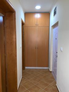 un couloir avec des armoires en bois et du carrelage dans l'établissement Apartman Joja, à Bar