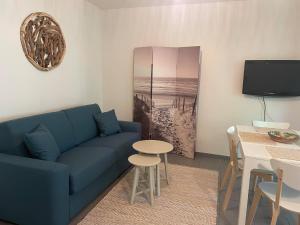 - un salon avec un canapé bleu et une table dans l'établissement Frenchyhomes☆T2 proche plage☆centre ville☆WIFI, à Lanton