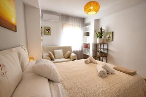 une chambre blanche avec un lit et une chaise dans l'établissement Cuencaloft paseo del Huecar, à Cuenca