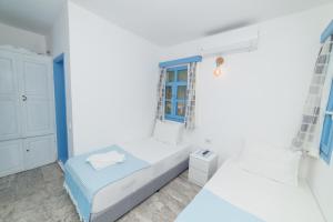 a bedroom with two beds and a window at Panorama Hotel Bodrum in Golturkbuku