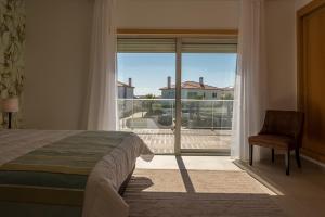 AmoreiraにあるVilla do Golf 9のベッドルーム1室(ベッド1台、大きな窓付)