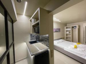 um pequeno quarto com uma cama e um lavatório em Jxn Rooms em Saturn
