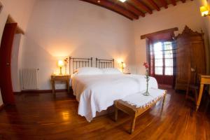 Un dormitorio con una gran cama blanca y una ventana en Hotel Boutique Posada La Basilica, en Pátzcuaro