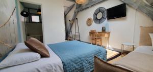 a bedroom with a blue bed and a mirror at Le Domaine d'Hérambault in Montcavrel