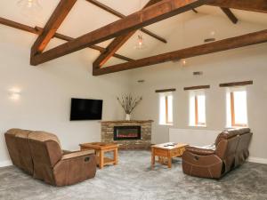 a living room with couches and a fireplace at Birkett Barn in Kirkby Stephen