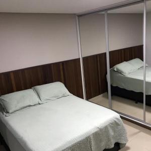 um quarto com uma cama e um espelho em Flat The Expression 1210 em Goiânia