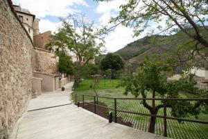 einen Gehweg durch einen Park mit einem Gebäude und Bäumen in der Unterkunft Huerto de Mateo Arana in Cuenca