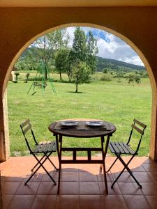 eine Terrasse mit einem Tisch und Stühlen sowie einem Spielplatz in der Unterkunft Val de Llous I 40 in Sainte-Léocadie