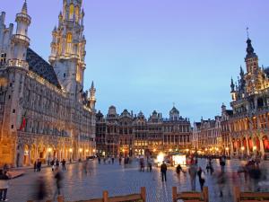 un groupe de personnes se promenant dans une rue avec des bâtiments dans l'établissement Hotel Queen Mary, à Bruxelles