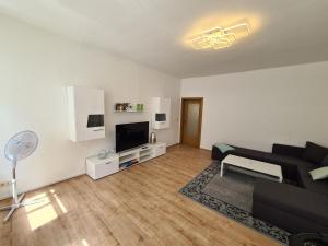 a living room with a black couch and a tv at Ferienwohnung 2 Christiansdorf Freiberg in Freiberg