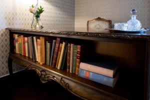 a book shelf filled with books and a vase of flowers at Jervell Gjestehus in Ålesund