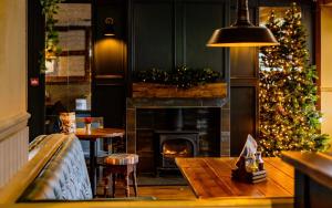 a living room with a christmas tree and a fireplace at The Balavoulin - Pub with Rooms in Aviemore