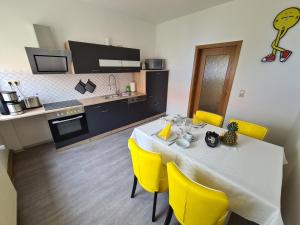 a dining room with a table and yellow chairs at Ferienwohnung 2 Christiansdorf Freiberg in Freiberg
