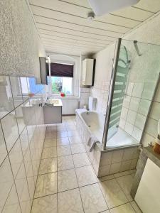 a bathroom with a tub and a shower and a sink at Ferienwohnung 2 Christiansdorf Freiberg in Freiberg +11 photos