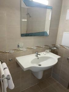 W łazience znajduje się biała umywalka i lustro. w obiekcie Hotel ECO Palace w Primorsku