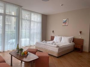 a bedroom with a large bed and a table at Hotel ECO Palace in Primorsko