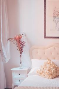 Un jarrón de flores en una mesita de noche junto a una cama en Bianca Cappello House, en Venecia
