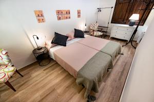 a bedroom with a large bed and a chair at Casa l'Escorretger in Calaceite