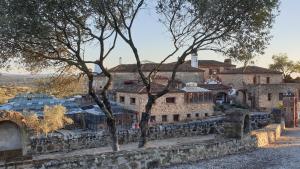 un grupo de edificios con árboles delante de ellos en Hotel Monasterio de Rocamador, en Almendral