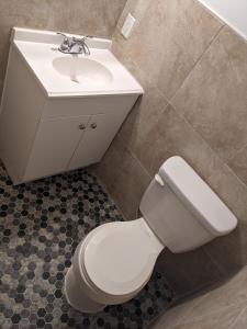 a bathroom with a white toilet and a sink at Beach Side Hotel in Myrtle Beach