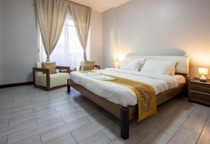 a bedroom with a large bed and a chair at Bay la sun , Luxury apartment with nice view in King Abdullah Economic City