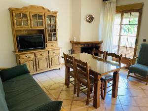 een woonkamer met een eettafel en een tv bij Apartamentos Margarita in Arroyo Frio