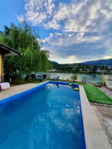 a swimming pool with a view of a river at Apartmani i sobe Okuka in Višegrad