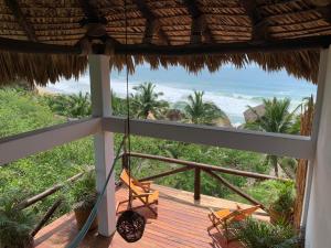 a view from a balcony of a beach with a view of the ocean at El Alquimista Yoga Spa in Zipolite
