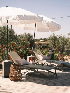 two lounge chairs and an umbrella on a patio at Rêves Étoilés in Setúbal