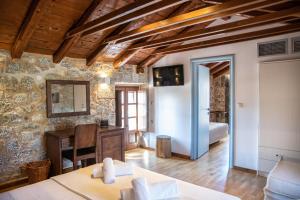 a living room with a table and a bedroom at Trapela Areopolis, Boutique Hotel in Areopoli