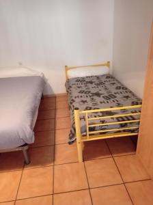 een kleine kamer met een bed en een wieg erin bij Plein pied dans maison de caractère in Montjaux