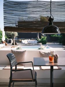 uma mesa e cadeira num quarto com vista para a piscina em Rêves Étoilés em Setúbal