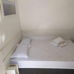 Habitación blanca pequeña con 2 camas en Loft Saint Tropez, en Arraial do Cabo