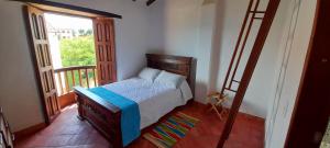 a bedroom with a bed in a room with a balcony at Alemau´s House Casa Hospedaje en Barichara in Barichara +27 photos