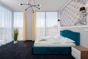 a bedroom with a large bed and a large window at Aquila Hotel in Zator