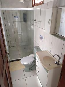 a bathroom with a shower and a toilet and a sink at Loft Saint Tropez in Arraial do Cabo