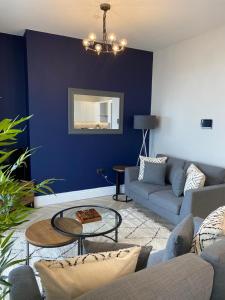 a blue living room with a couch and a table at Belmont Apartment 2 in Aberystwyth