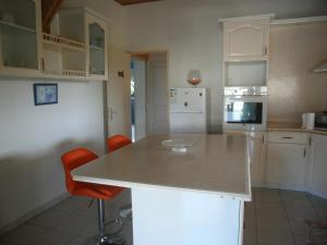 a kitchen with white cabinets and a white counter top at Villa Grandes pièces in Petit-Bourg