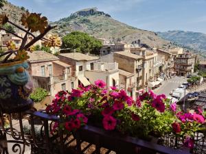 a view of a city with flowers on a balcony at B&B Joan's Heritage in Taormina