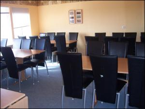 uma sala de aula vazia com mesas e cadeiras e mesas em Guesthouse Hof em Hofgarðar