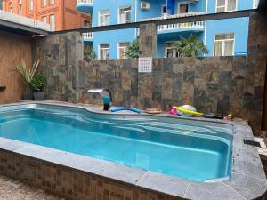 una piscina con grifo frente a un edificio en Hotel Nika, en Adler