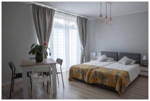 sypialnia z łóżkiem i biurkiem oraz stół z tableablish w obiekcie Pokoje na wynajem w Gdańsku