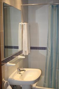 a bathroom with a sink and a mirror and a shower at Apartamentos Torrelaguna in Vera