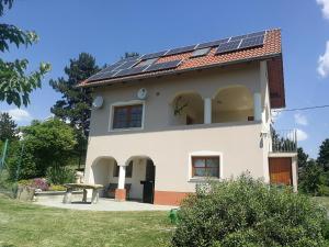 a house with solar panels on the roof at Bottyahát guesthouse in Rezi