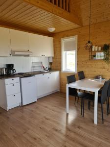 a kitchen and dining room with a table and chairs at Starmýri 2 Cottages in Starmýri