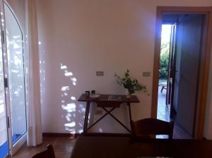 Habitación con mesa y puerta que da a un patio. en A casa di Maurizio, en Rosa Marina
