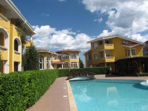 a villa with a swimming pool in front of a building at Blue Orange Beach Resort in Sozopol