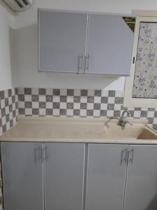 eine Küche mit weißen Schränken und einem Waschbecken in der Unterkunft ريـــــم للشقق المفروشة والأجنحــة الفـندقيـة Reem Hotel in Khobar