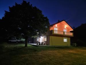 ein Haus mit einem Picknicktisch davor in der Nacht in der Unterkunft Apartmani Svitavac in Trebinje